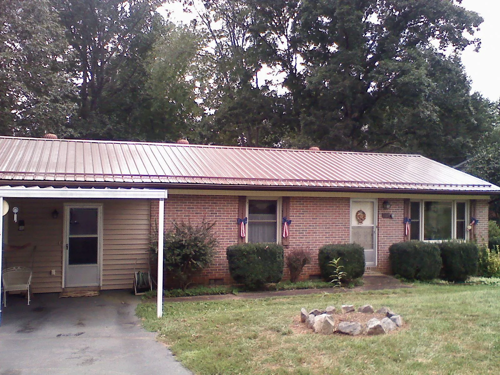 Bronze metal roof and carport on a brick ranch home — Roof Repair work by our crew in Dixie